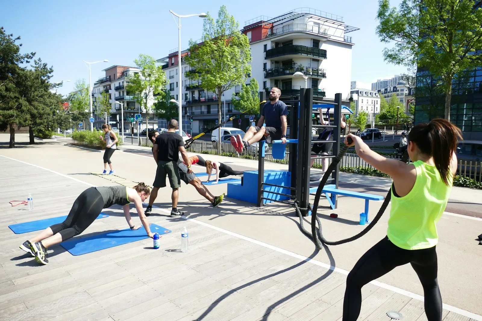 Groep traint met battle ropes en planks in de buitenlucht